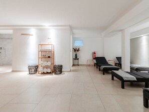 Ein Spa-Bereich mit einer Rezeption, einem Handtuchregal, einem Feuerlöscher und zwei Lounge-Sesseln.