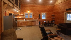 Ein gemütliches Interieur im Blockhausstil mit Küche, Essbereich und Sitzgelegenheit.
