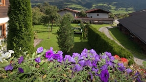 A mountainous landscape with houses and a garden with purple flowers. - Cosy Holiday Home Near ski Area (Piesendorf)