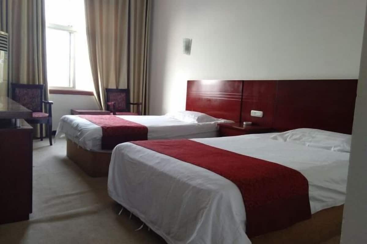 Una habitación de hotel con dos camas, un escritorio y una silla.