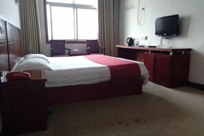 A hotel room with a bed, a desk, a television, and a window with curtains. - Jinfuyuan Express Hotel (Fengtai)