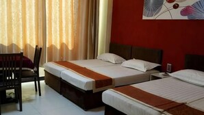 Een hotelkamer met twee bedden, een bureau en een stoel.