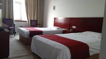Habitación de hotel con dos camas, un escritorio y una silla.
