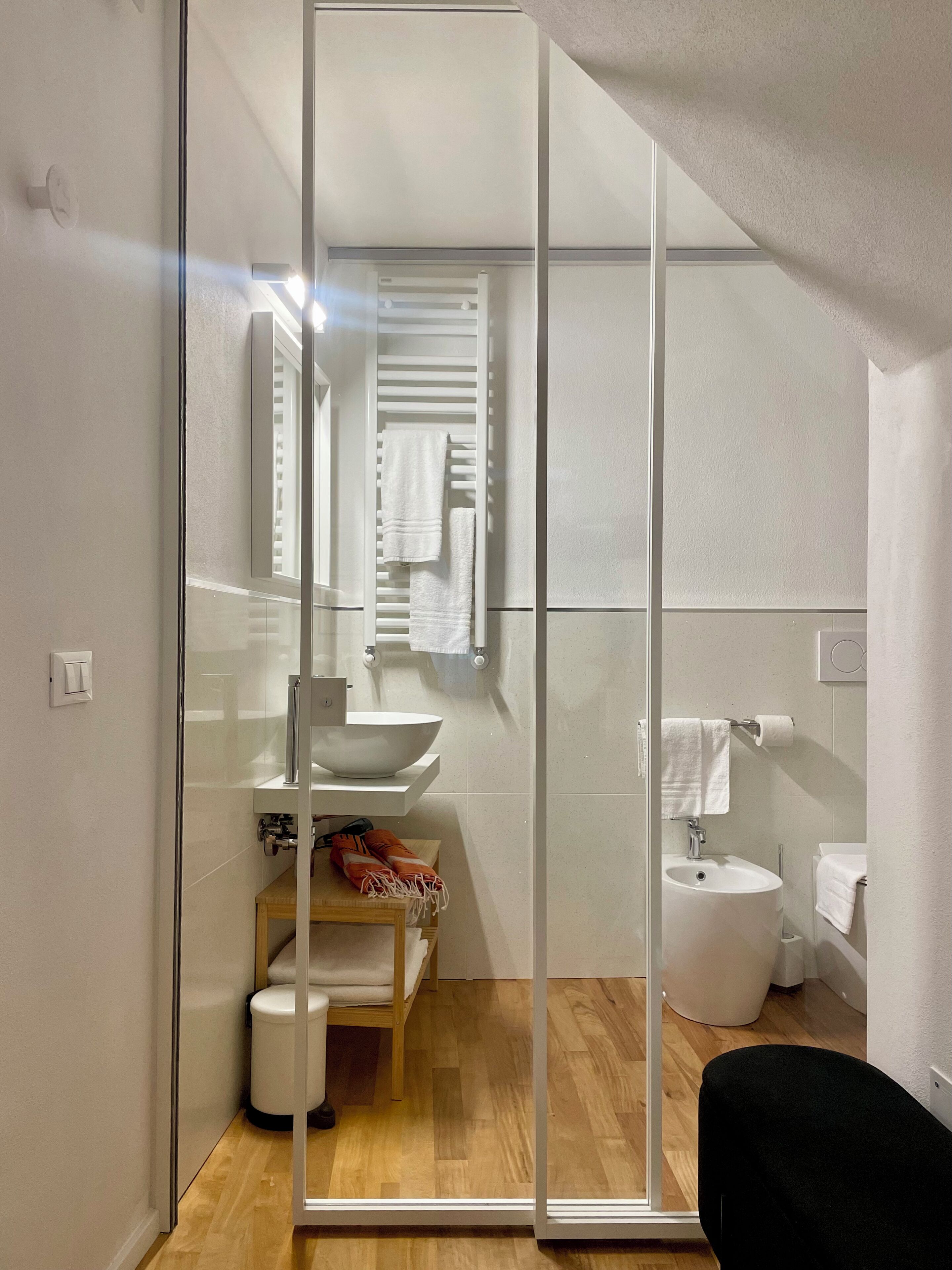 Une salle de bain moderne avec une paroi en verre, un lavabo, des toilettes et un espace douche.