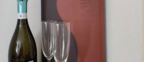 A bottle of Major Rivus wine, two empty wine glasses, and a leather-bound notebook with embossed text.