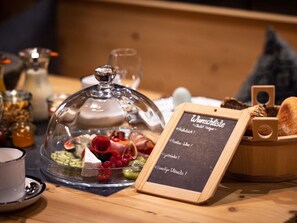 Un bufé de desayuno con una variedad de frutas, quesos y panes.