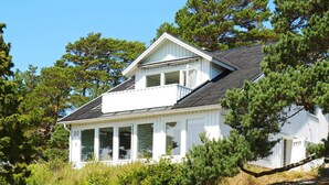 A white building with a balcony, surrounded by trees and grass. - 4 Star Holiday Home in Stromstad (Stromstad)