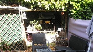 A patio with a welcome mat, wicker furniture, and a lattice fence.