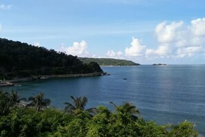 A coastal landscape with a clear view of the sea, a small island in the distance, and lush greenery in the foreground. - Tinghai Yushu Hotel (Taishan)