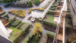 A rooftop garden with neatly trimmed hedges, a small white building, and a pathway. - Apartment in Koksijde Near the Sea (Koksijde)