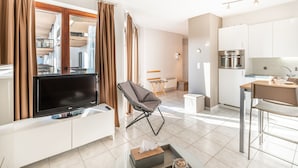 A modern apartment with a living area, kitchenette, and a view of the building's exterior. - Apartment in Koksijde Near the Sea (Koksijde)