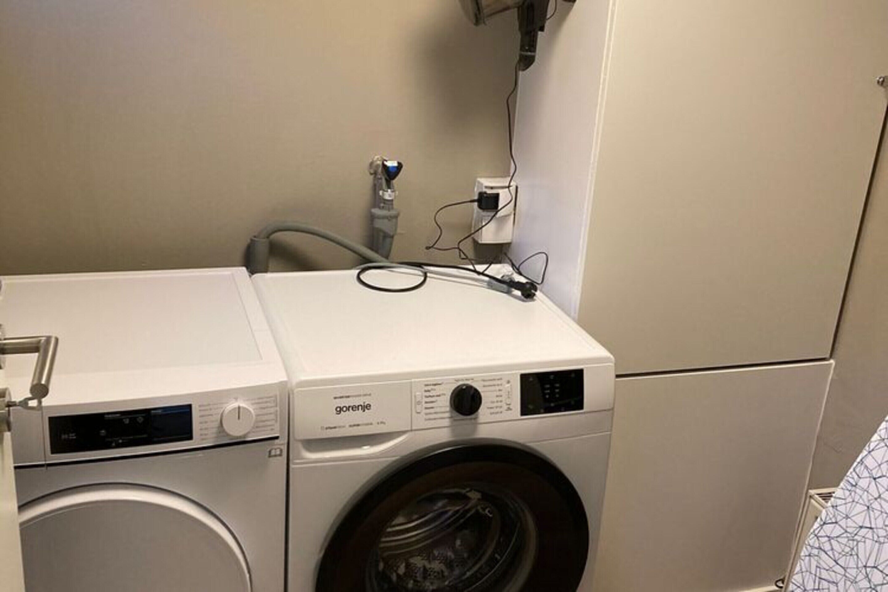 Una lavadora de carga frontal con panel de control y manguera.