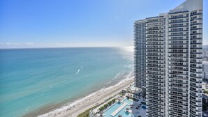 A high-rise hotel with a pool and beach view.