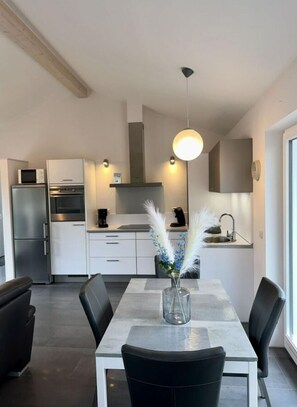 Enjoy cooking and dining in this well-equipped kitchen with a central island, microwave, oven, and coffee machine.