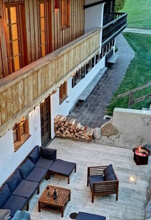 A modern outdoor patio with a sofa set, a coffee table, and a fire pit. - Kehlpoint Comfortable Holiday Residence (Miesbach)