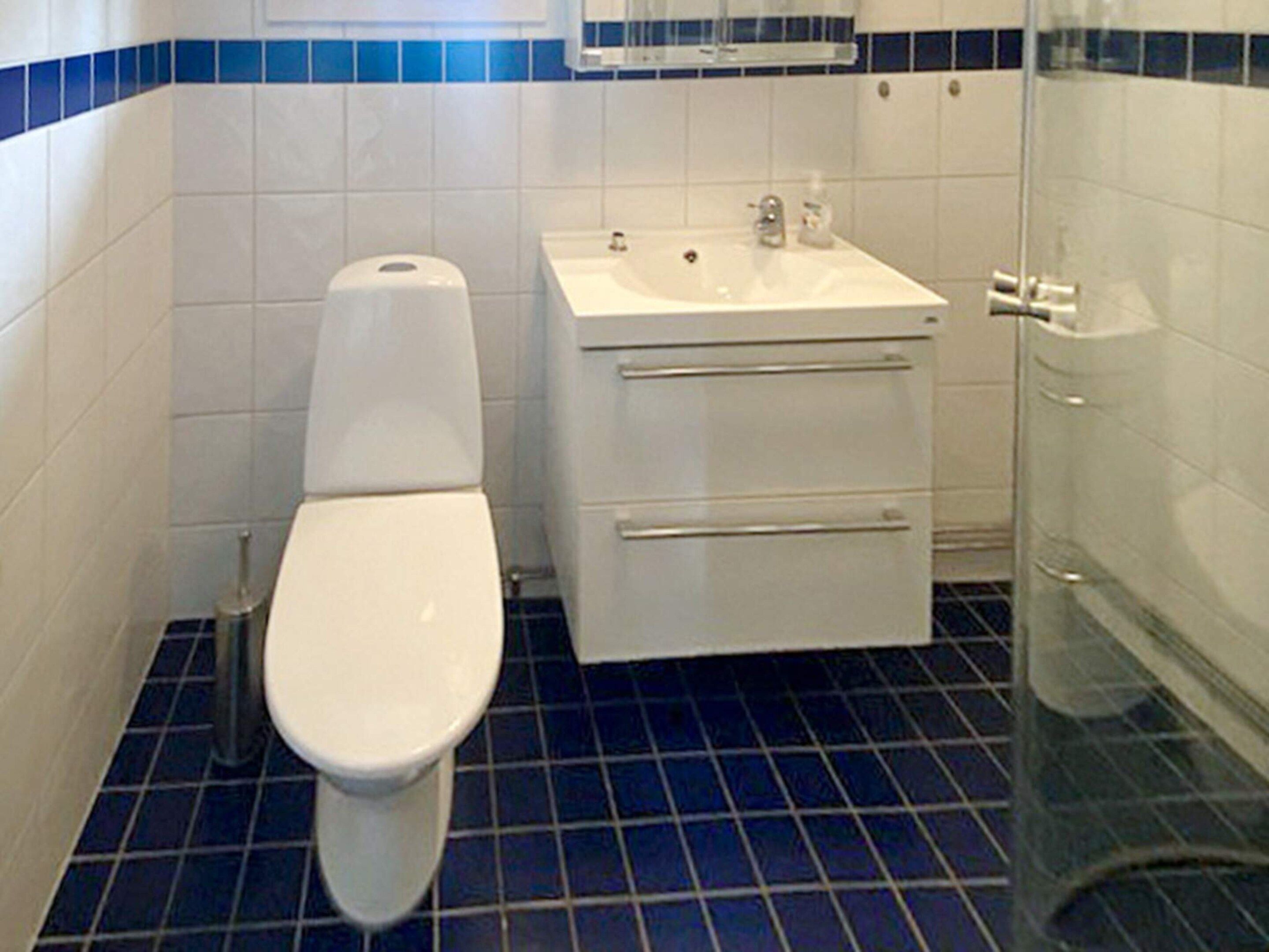 A bathroom with a toilet, sink, and shower.