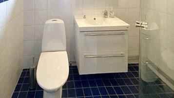 A bathroom with a toilet, sink, and shower.