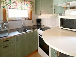 A kitchen with a sink, stove, microwave, and cabinets. - 5 Star Holiday Home in Ljustero (Ljusterö)
