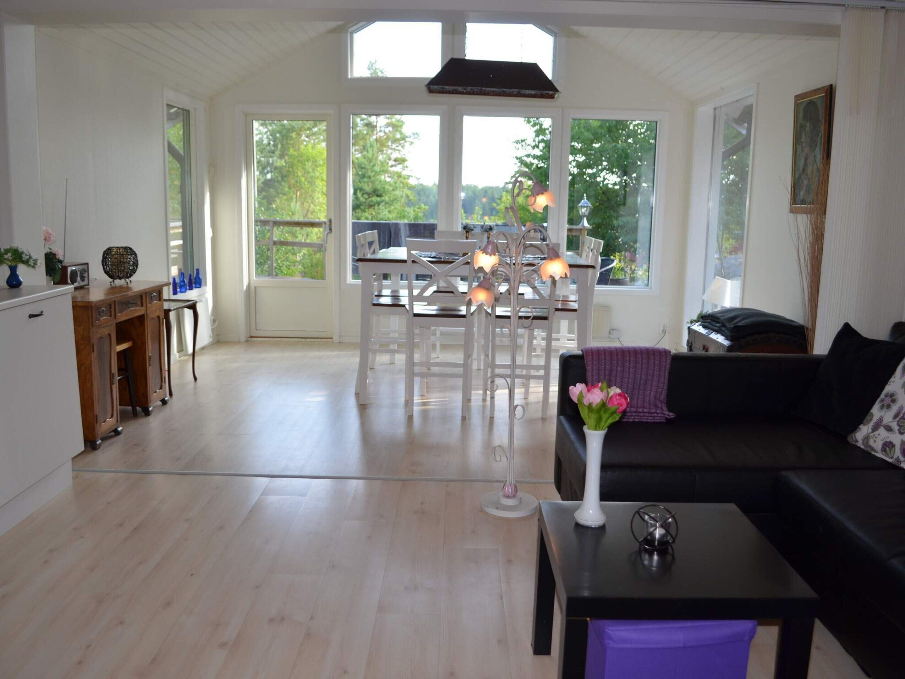 A spacious living area with a dining table, chairs, a sofa, and a coffee table.