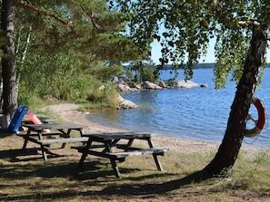 A lakeside picnic area with benches and a lifebuoy. - 5 Star Holiday Home in Ljustero (Ljusterö)