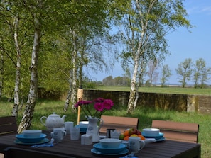 A table set outdoors with a view of a water body and trees. - Holiday Home Darsskieker (Pruchten)
