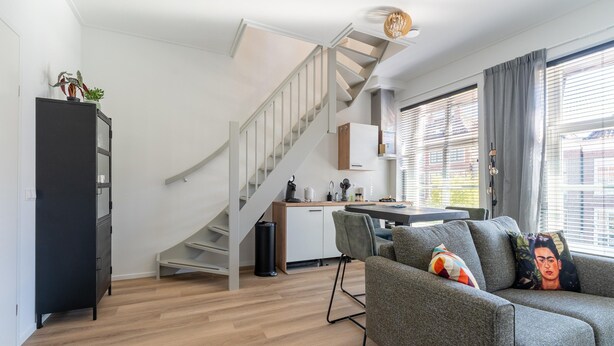 A modern living room with a staircase, a dining area, and a kitchen. - Modern Apartments in the Heart of Sneek (Sneek)