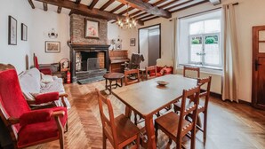 Una sala de estar acogedora con chimenea, muebles de madera y un ventanal grande.