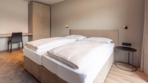Un dormitorio moderno con una cama grande, un escritorio y un armario.