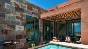 A modern outdoor pool area with a stone wall, a grill, and a seating area with a view of the interior. - Villa in Salobre Golf With Private Pool (San Bartolomé de Tirajana)