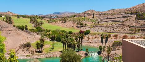 Un campo de golf con un estanque y palmeras.