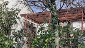 A building with a red roof and a tree in the foreground. - Apartments Rudi - One Bedroom Apartment With Terrace (Novi Vinodolski)