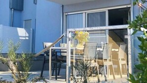 Un bâtiment moderne à deux étages, doté d’un balcon et d’un espace patio.