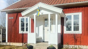 A red and white building with a tiled roof, a flag, and a sign that reads "Mormors Stuga". - 7 Person Holiday Home in Forsheda (Forsheda)