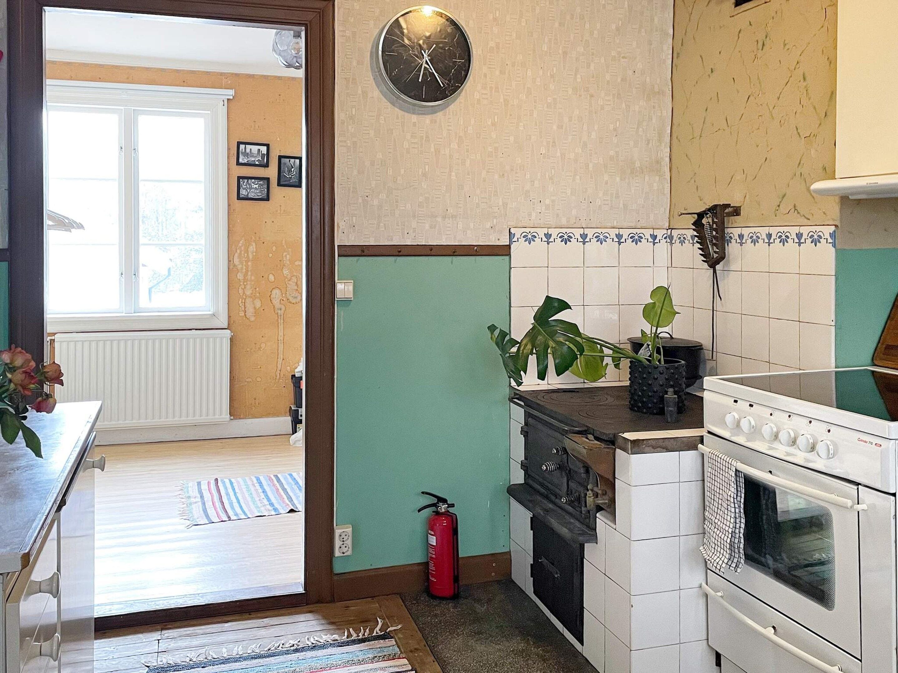 A kitchen with a stove, oven, and a clock on the wall.