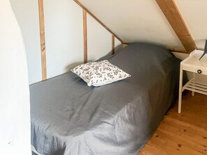 A small, single-bed room with a sloped ceiling and wooden beams. - 7 Person Holiday Home in Forsheda (Forsheda)