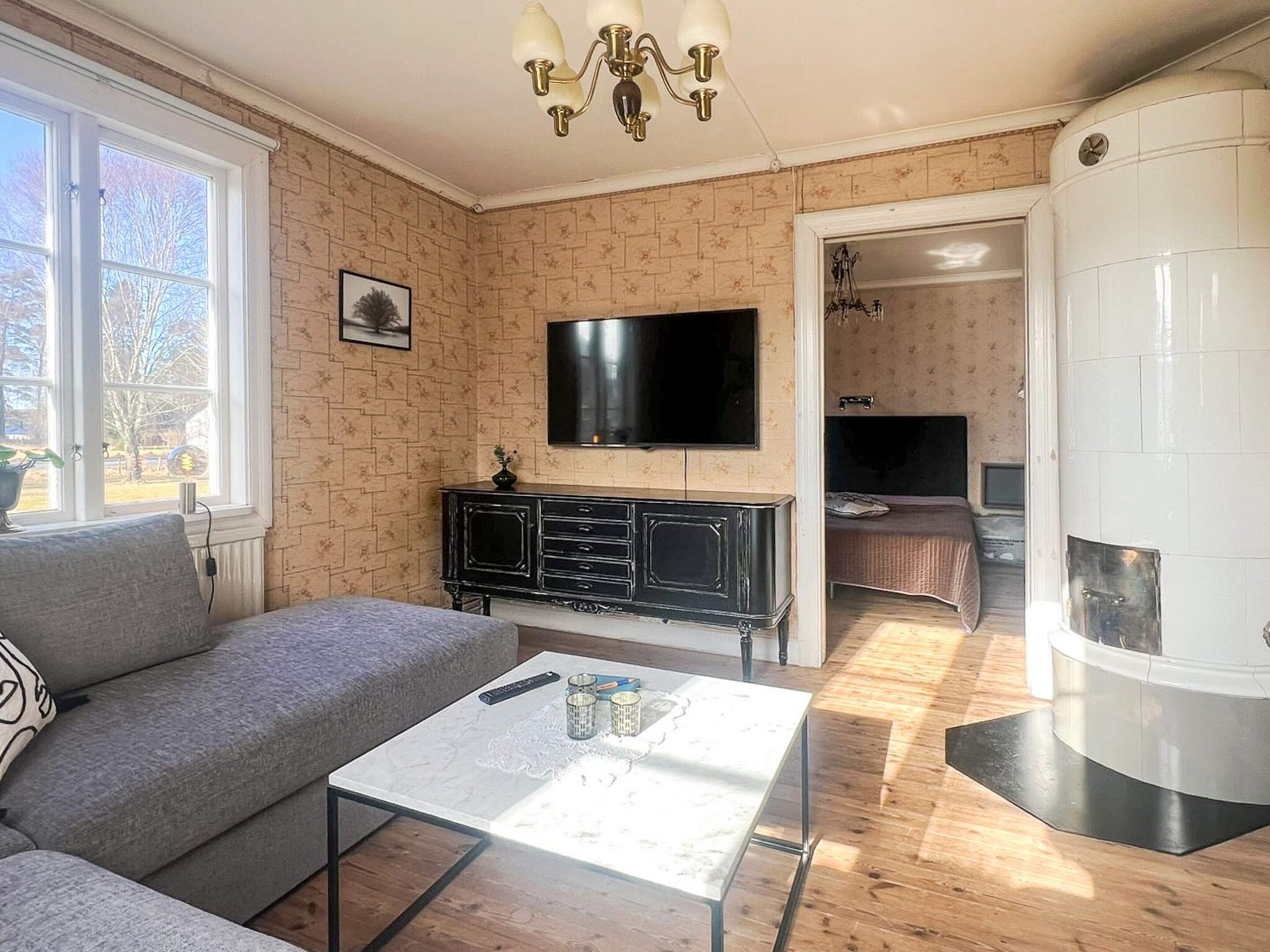 Una sala de estar con sofá, mesa de centro, televisor y chimenea.