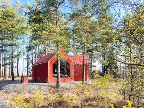 A red cabin surrounded by trees in a forest. - 7 Person Holiday Home in Forsheda (Forsheda)