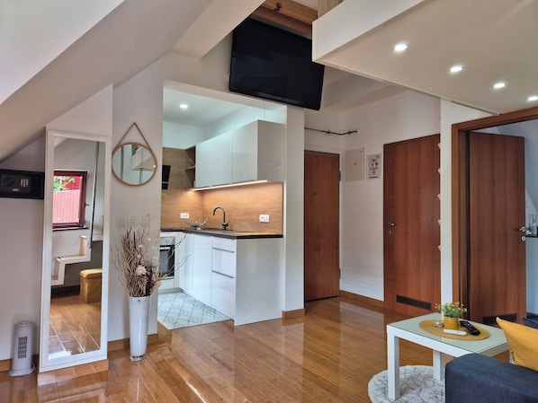 A modern living room with a sofa, a coffee table, and a TV mounted on the wall.