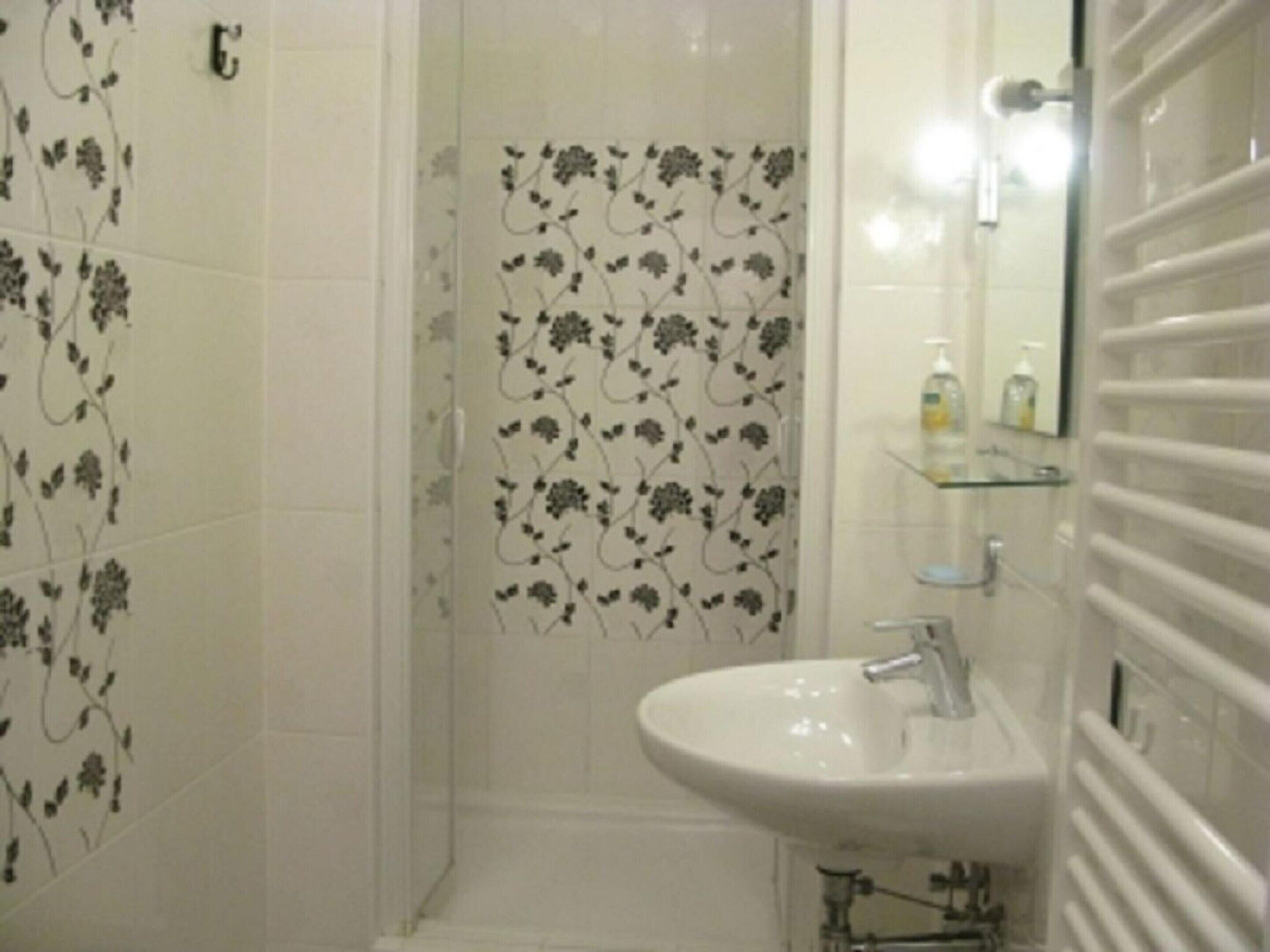 A bathroom with a shower, a sink, and a mirror.
