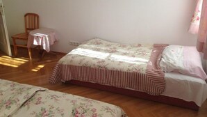 Une chambre avec un lit simple, une chaise et une petite table.