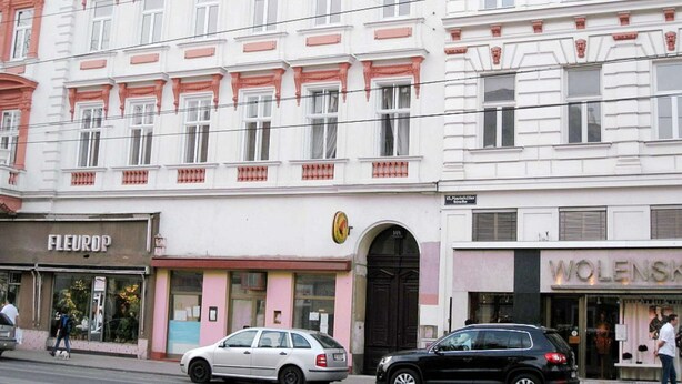 Un immeuble à plusieurs étages, de style architectural classique, caractérisé par des encadrements de fenêtres ouvragés et des éléments décoratifs.