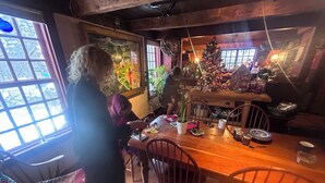 Ein gemütlicher Essbereich mit Holztisch, Stühlen und einem Weihnachtsbaum.