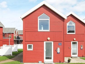 A red building with a white door, a small window, and a number sign indicating room 35-75. - 6 Person Holiday Home in Hadsund (Hadsund)