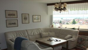 A living room with a beige sofa, a wooden coffee table, and a patterned rug. - With Lake and Alpine View (Immenstaad am Bodensee)