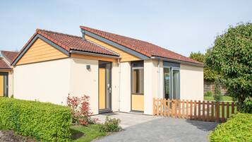A single-story building with a tiled roof, a front door, and a small porch area.