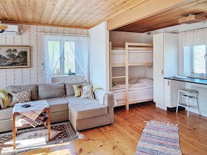 A cozy room with a sofa, a bunk bed, a desk, and a window. - 4 Star Holiday Home in Ljusdal (Ljusdal)