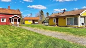 Une rangée de maisons avec un chemin de gravier devant, sous un ciel bleu dégagé.