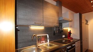 Una cocina moderna con armarios de madera oscura, electrodomésticos de acero inoxidable y lavavajillas integrado.
