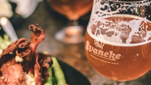 A glass of Svanehe beer with foam, a plate of food including roasted meat and asparagus. - 4 Person Holiday Home in Svaneke (Svaneke)