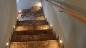 A staircase with wooden handrails and illuminated steps. - Holiday Apartment Ponywiese (Ihlow)